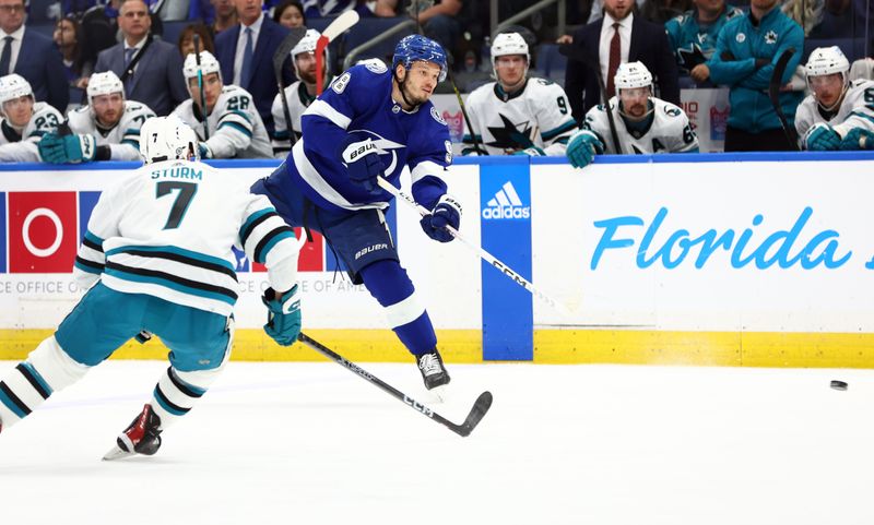 Feb 7, 2023; Tampa, Florida, USA; Tampa Bay Lightning defenseman Mikhail Sergachev (98) shoots as San Jose Sharks center Nico Sturm (7)  defends during the first period at Amalie Arena. Mandatory Credit: Kim Klement-USA TODAY Sports