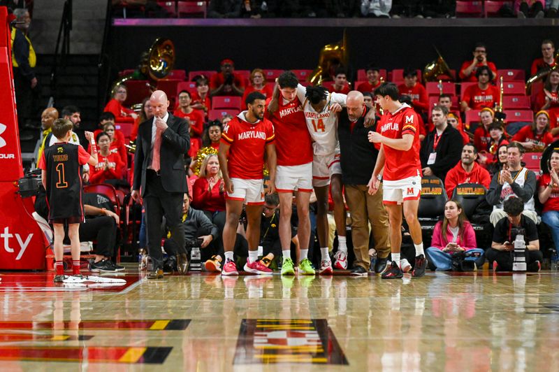 Feb 14, 2024; College Park, Maryland, USA;  Maryland Terrapins forward Mady Traore (14) is helped off the court by teammates during the second half against the Iowa Hawkeyes  at Xfinity Center. Mandatory Credit: Tommy Gilligan-USA TODAY Sports