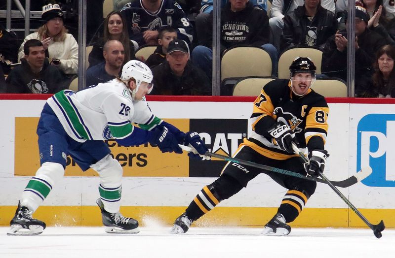 Nov 27, 2024; Pittsburgh, Pennsylvania, USA;  Pittsburgh Penguins center Sidney Crosby (87) moves the puck against Vancouver Canucks left wing Danton Heinen (20) during the second period at PPG Paints Arena. Mandatory Credit: Charles LeClaire-Imagn Images