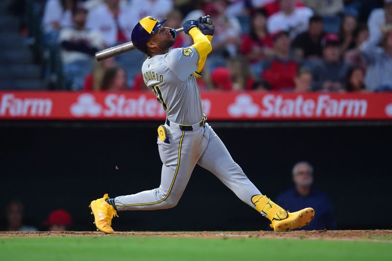 Jun 18, 2024; Anaheim, California, USA;  Milwaukee Brewers outfielder Jackson Chourio (11) hits a sacrifice RBI against the Los Angeles Angels during the sixth inning at Angel Stadium. Mandatory Credit: Gary A. Vasquez-USA TODAY Sports