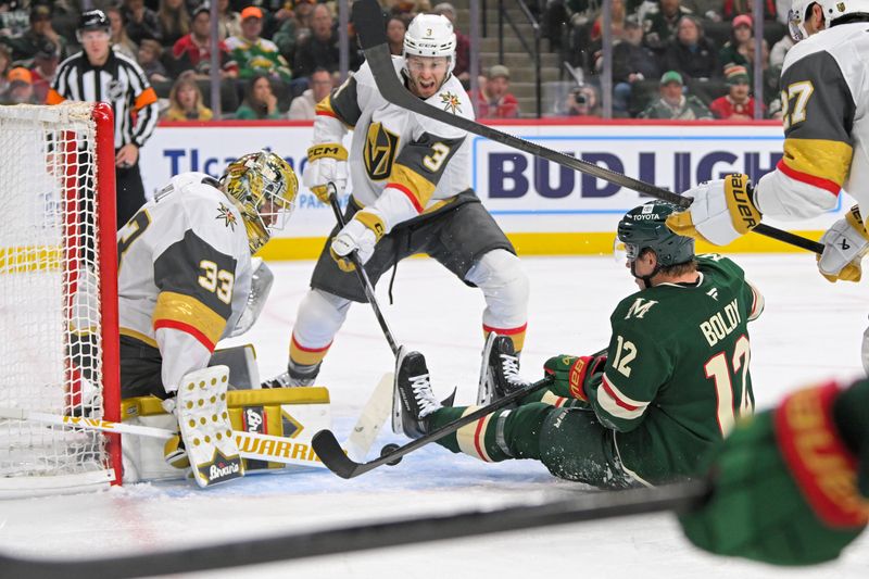 May 1, 2025; Saint Paul, Minnesota, USA;  Vegas Golden Knights goalie Adin Hill (33) makes a save on Minnesota Wild forward Matt Boldy (12) as defenseman Brayden McNabb (3) defends during the second period in game six of the first round of the 2025 Stanley Cup Playoffs at Xcel Energy Center. Mandatory Credit: Nick Wosika-Imagn Images