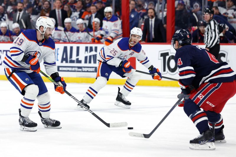 Mar 26, 2024; Winnipeg, Manitoba, CAN; Edmonton Oilers center Adam Henrique (19) skates up the ice towards Winnipeg Jets defenseman Neal Pionk (4) in the first period at Canada Life Centre. Mandatory Credit: James Carey Lauder-USA TODAY Sports