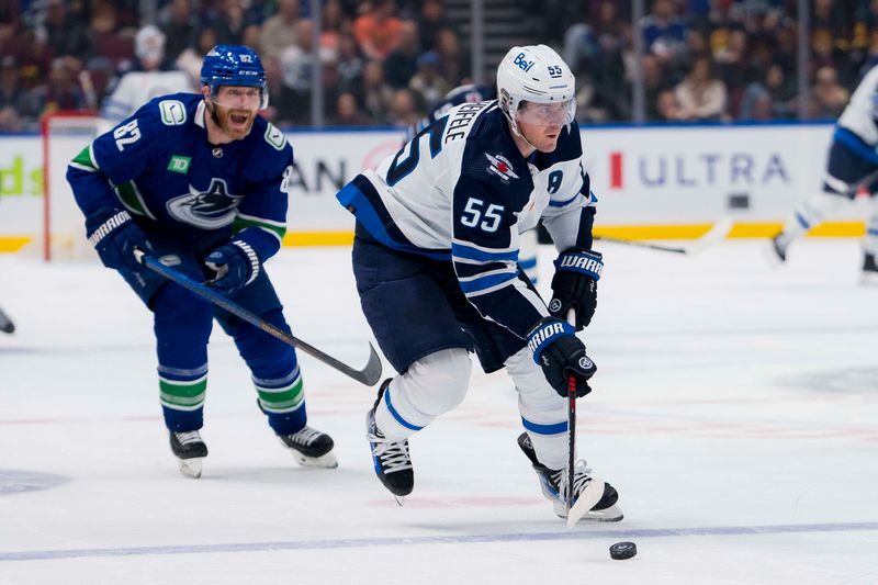 Feb 17, 2024; Vancouver, British Columbia, CAN; Winnipeg Jets forward Mark Scheifele (55) handles the puck against the Vancouver Canucks in the third period at Rogers Arena. Jets won 4-2. Mandatory Credit: Bob Frid-USA TODAY Sports