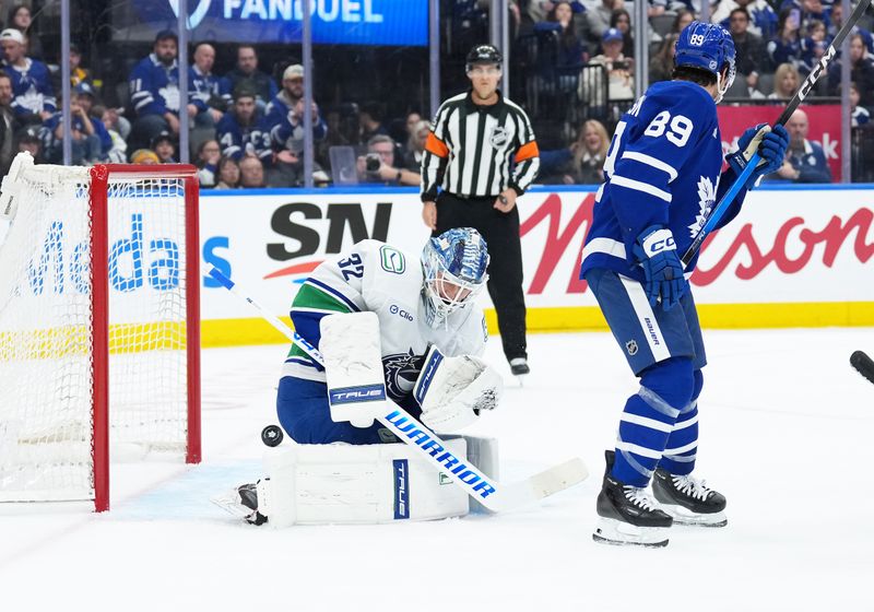 Jan 10, 2026; Toronto, Ontario, CAN; Toronto Maple Leafs left wing Nicholas Robertson (89) provides a screen as Vancouver Canucks goaltender Kevin Lankinen (32) tries to stop the puck during the third period at Scotiabank Arena. Mandatory Credit: Nick Turchiaro-Imagn Images