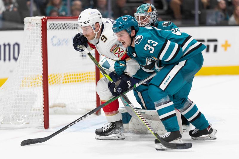 Nov 14, 2023; San Jose, California, USA; Florida Panthers center Sam Bennett (9) and San Jose Sharks defenseman Calen Addison (33) chase after the puck during the third period at SAP Center at San Jose. Mandatory Credit: Stan Szeto-USA TODAY Sports