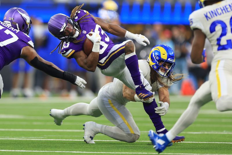 Minnesota Vikings running back Aaron Jones (33) is tackled by Los Angeles Rams linebacker Christian Rozeboom (56) during the first half of an NFL football game, Thursday, Oct. 24, 2024, in Inglewood, Calif. (AP Photo/Ryan Sun)