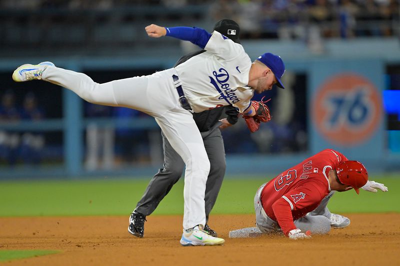 Jun 21, 2024; Los Angeles, California, USA;  Los Angeles Angels left fielder Taylor Ward (3) beats the tag by Los Angeles Dodgers second baseman Gavin Lux (9) for a stolen base in the 10th inning at Dodger Stadium. Mandatory Credit: Jayne Kamin-Oncea-USA TODAY Sports