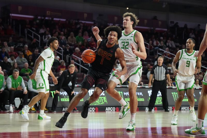 Dec 4, 2024; Los Angeles, California, USA; Southern California Trojans guard Desmond Claude (1) dribbles against Oregon Ducks center Nate Bittle (32) in the first half at Galen Center. Mandatory Credit: Kirby Lee-Imagn Images