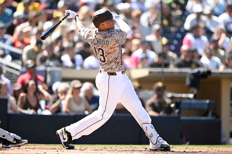 Sep 28, 2025; San Diego, California, USA; San Diego Padres third baseman Manny Machado (13) hits a solo home run during the third inning against the Arizona Diamondbacks at Petco Park. Mandatory Credit: Denis Poroy-Imagn Images