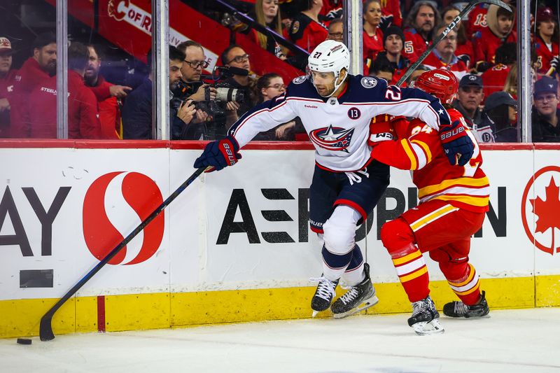 Dec 3, 2024; Calgary, Alberta, CAN; Columbus Blue Jackets center Zachary Aston-Reese (27) and Calgary Flames defenseman Jake Bean (24) battles for the puck during the third period at Scotiabank Saddledome. Mandatory Credit: Sergei Belski-Imagn Images