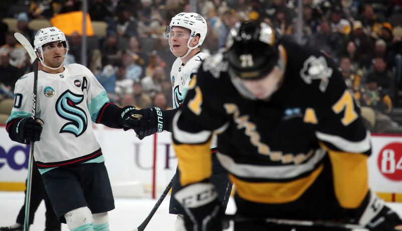 Jan 14, 2025; Pittsburgh, Pennsylvania, USA;  Seattle Kraken center Matty Beniers (left) congratulates right wing Kaapo Kakko (middle) on his goal as Pittsburgh Penguins center Evgeni Malkin (71) reacts during the third period at PPG Paints Arena. Mandatory Credit: Charles LeClaire-Imagn Images