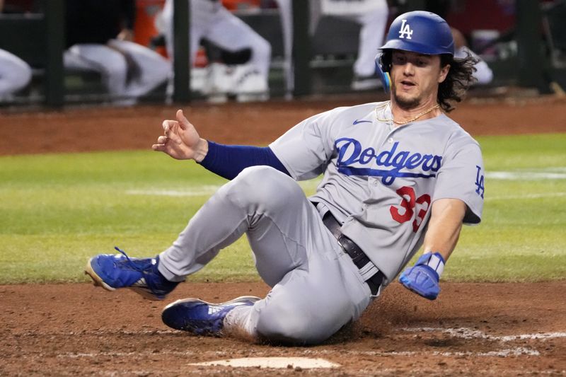 Aug 8, 2023; Phoenix, Arizona, USA; Los Angeles Dodgers center fielder James Outman (33) slides and scores a run against the Arizona Diamondbacks during the ninth inning at Chase Field. Mandatory Credit: Joe Camporeale-USA TODAY Sports