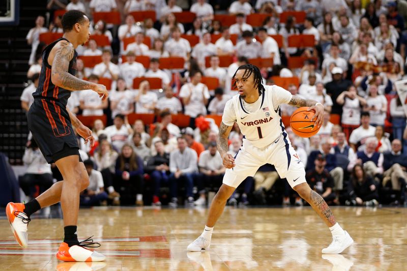 Feb 5, 2024; Charlottesville, Virginia, USA; Virginia Cavaliers guard Dante Harris (1) controls the ball as Miami (Fl) Hurricanes guard Matthew Cleveland (0) defends during the second half at John Paul Jones Arena. Mandatory Credit: Amber Searls-USA TODAY Sports