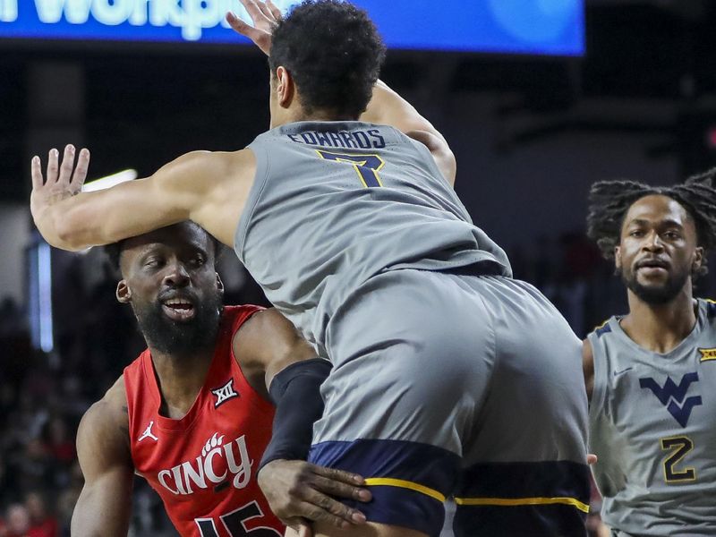 Mar 9, 2024; Cincinnati, Ohio, USA; Cincinnati Bearcats forward John Newman III (15) passes the ball against West Virginia Mountaineers center Jesse Edwards (7) in the first half at Fifth Third Arena. Mandatory Credit: Katie Stratman-USA TODAY Sports