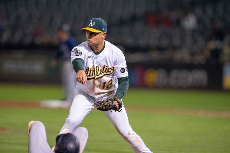 Sep 19, 2023; Oakland, California, USA; Oakland Athletics third baseman Aledmys Diaz (12) tags out Seattle Mariners second baseman Sam Haggerty (0) during the seventh inning at Oakland-Alameda County Coliseum. Mandatory Credit: Neville E. Guard-USA TODAY Sports