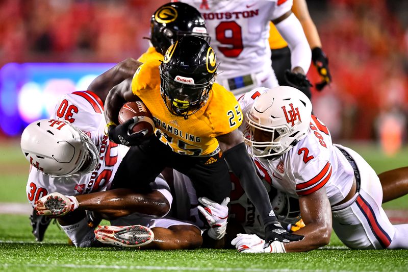 Sep 18, 2021; Houston, Texas, USA;  Houston Cougars linebacker Deontay Anderson (2) and defensive lineman Alexander Duke (30) and linebacker Elijah Gooden (26) tackle Grambling State Tigers defensive back Devanir Martin (25) during the fourth quarter at TDECU Stadium. Mandatory Credit: Maria Lysaker-USA TODAY Sports