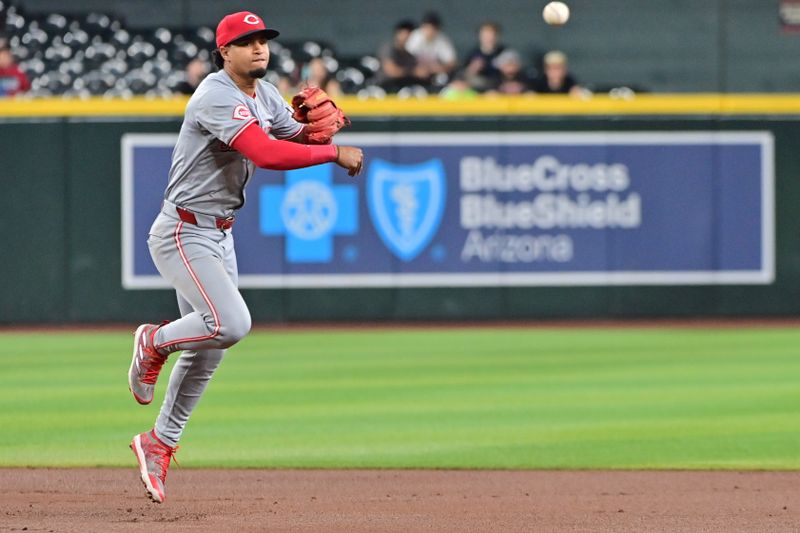 May 15, 2024; Phoenix, Arizona, USA;  Cincinnati Reds second base Santiago Espinal (4) turns a double play in the first inning against the Arizona Diamondbacks at Chase Field. Mandatory Credit: Matt Kartozian-USA TODAY Sports