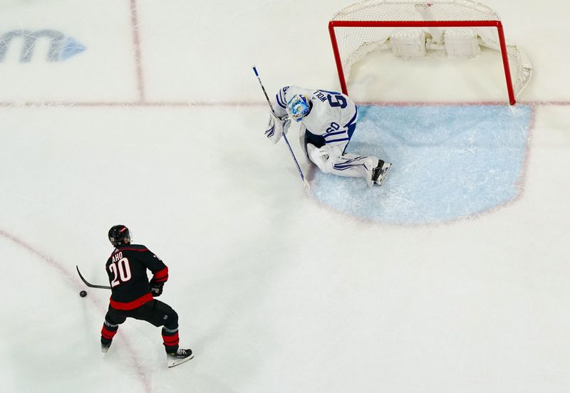 Mar 24, 2024; Raleigh, North Carolina, USA;  Carolina Hurricanes center Sebastian Aho (20) skates in with the puck in on Toronto Maple Leafs goaltender Joseph Woll (60) during the second period at PNC Arena. Mandatory Credit: James Guillory-USA TODAY Sports