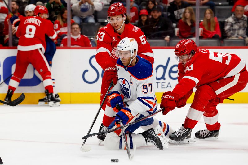 Oct 19, 2025; Detroit, Michigan, USA;  Edmonton Oilers center Connor McDavid (97) plays the puck from his knees against  Detroit Red Wings defenseman Moritz Seider (53) during the first period at Little Caesars Arena. Mandatory Credit: Rick Osentoski-Imagn Images
