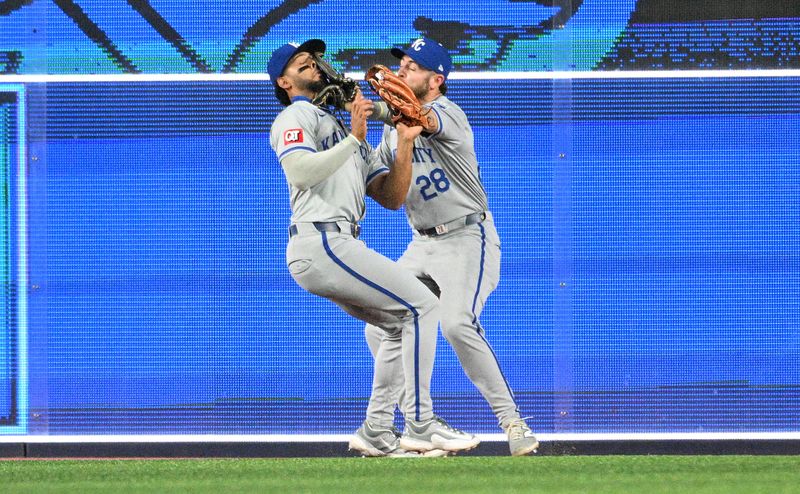 Apr 29, 2024; Toronto, Ontario, CAN; Kansas City Royals left fielder MJ Melendez (1) and center Kyle Isbel (28) collide as they pursue a fly ball hit by Toronto Blue Jays shortstop Isiah Kiner-Falefa (not shown) in the seventh inning at Rogers Centre. Melendez made the catch. Mandatory Credit: Dan Hamilton-USA TODAY Sports