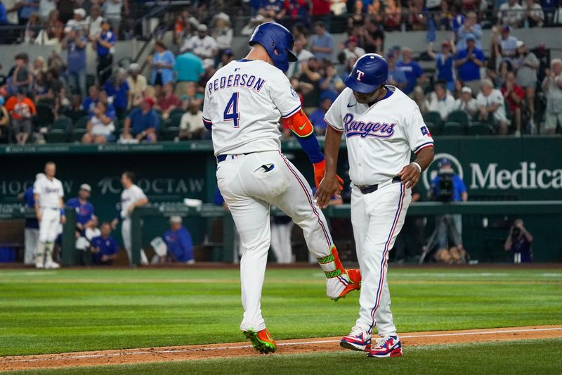 May 17, 2025; Arlington, Texas, USA; Texas Rangers first baseman Joc Pederson (4) low fives third base coach Tony Beasley (27) after hitting a two-run home run during the sixth inning against the Houston Astros at Globe Life Field. Mandatory Credit: Raymond Carlin III-Imagn Images