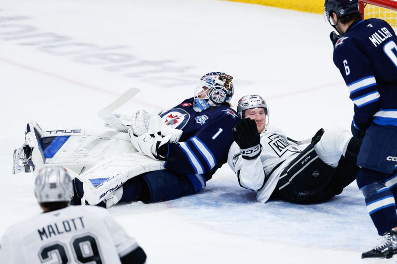 Jan 9, 2026; Winnipeg, Manitoba, CAN; Los Angeles Kings forward Taylor Ward (52) collides with Winnipeg Jets goalie Eric Comrie (1) during the third period at Canada Life Centre. Mandatory Credit: Terrence Lee-Imagn Images
