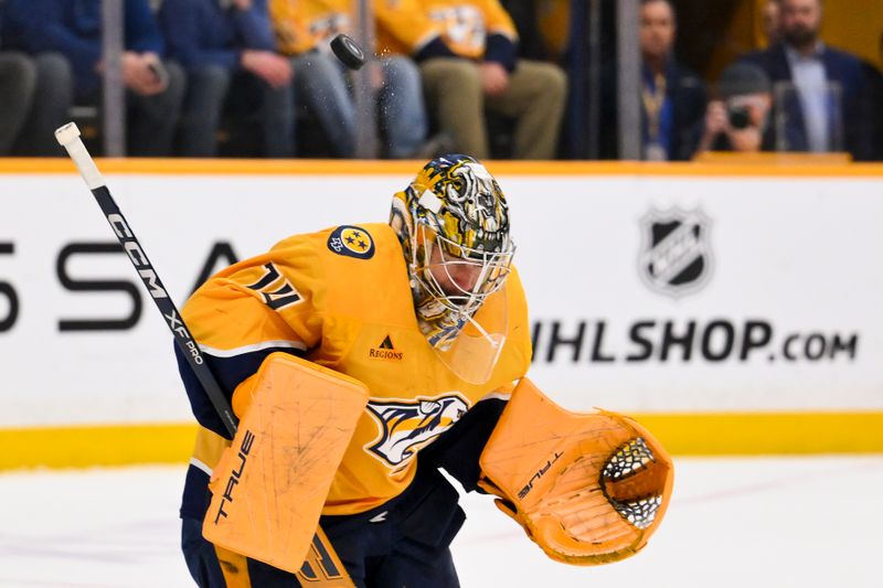 Mar 2, 2026; Nashville, Tennessee, USA;  Nashville Predators goaltender Juuse Saros (74) takes a puck of the helmet against the Detroit Red Wings during the first period at Bridgestone Arena. Mandatory Credit: Steve Roberts-Imagn Images