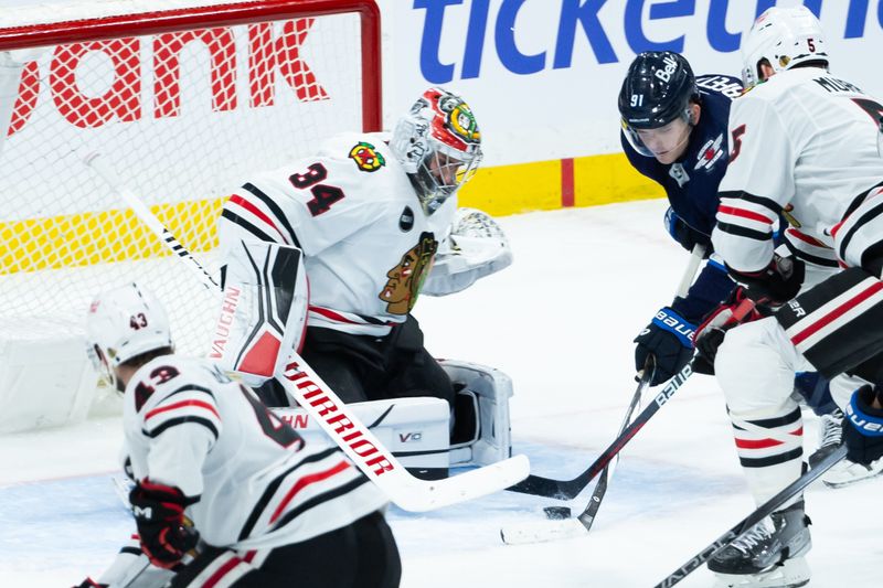 Jan 11, 2024; Winnipeg, Manitoba, CAN; Chicago Blackhawks defenseman Connor Murphy (5) checks Winnipeg Jets forward Cole Perfetti (91) in front of Chicago Blackhawks goalie Petr Mrazek (34) during the third period at Canada Life Centre. Mandatory Credit: Terrence Lee-USA TODAY Sports