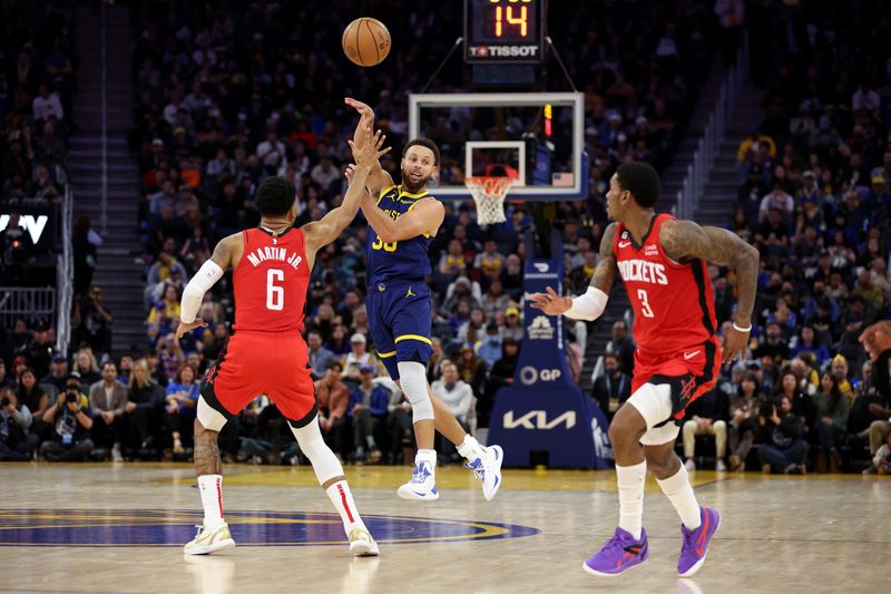 SAN FRANCISCO, CALIFORNIA - DECEMBER 03: Stephen Curry #30 of the Golden State Warriors passes around Kenyon Martin Jr. #6 and \ho at Chase Center on December 03, 2022 in San Francisco, California. NOTE TO USER: User expressly acknowledges and agrees that, by downloading and or using this photograph, User is consenting to the terms and conditions of the Getty Images License Agreement.  (Photo by Ezra Shaw/Getty Images)