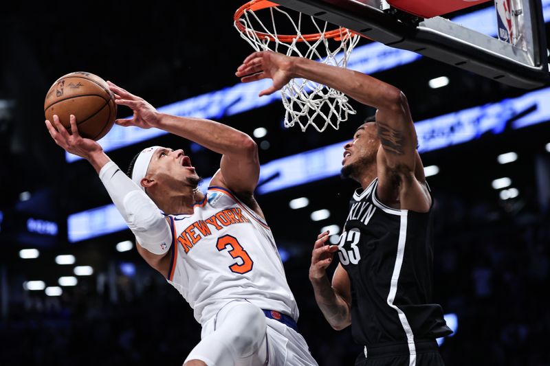 NEW YORK, NEW YORK - JANUARY 23: Josh Hart #3 of the New York Knicks is defended by Nic Claxton #33 of the Brooklyn Nets during the fourth quarter of the game at Barclays Center on January 23, 2024 in the Brooklyn borough of New York City.  NOTE TO USER: User expressly acknowledges and agrees that, by downloading and or using this photograph, User is consenting to the terms and conditions of the Getty Images License Agreement. (Photo by Dustin Satloff/Getty Images)