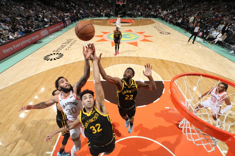 SAN ANTONIO, TX - MARCH 31: Julian Champagnie #30 of the San Antonio Spurs and Trayce Jackson-Davis #32 and Andrew Wiggins #22 of the Golden State Warriors go up for a rebound during the game on March 31, 2024 at the Frost Bank Center in San Antonio, Texas. NOTE TO USER: User expressly acknowledges and agrees that, by downloading and or using this photograph, user is consenting to the terms and conditions of the Getty Images License Agreement. Mandatory Copyright Notice: Copyright 2024 NBAE (Photos by Joe Murphy/NBAE via Getty Images)