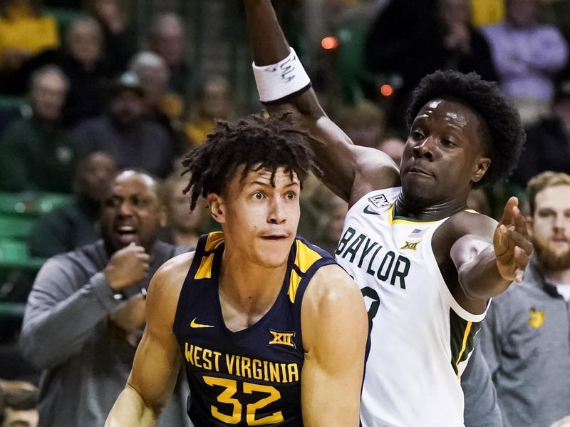 Feb 13, 2023; Waco, Texas, USA; West Virginia Mountaineers forward James Okonkwo (32) is defended by Baylor Bears guard Langston Love (13) during the first half at Ferrell Center. Mandatory Credit: Raymond Carlin III-USA TODAY Sports