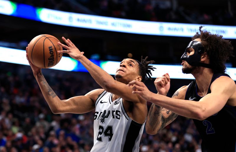 DALLAS, TX - FEBRUARY 14: Devin Vassell #24 of the San Antonio Spurs drives inside as Dereck Lively II #2 of the Dallas Mavericks defends in the second half at American Airlines Center on February 14, 2024 in Dallas, Texas. NOTE TO USER: User expressly acknowledges and agrees that, by downloading and or using this photograph, User is consenting to the terms and conditions of the Getty Images License Agreement. (Photo by Ron Jenkins/Getty Images)