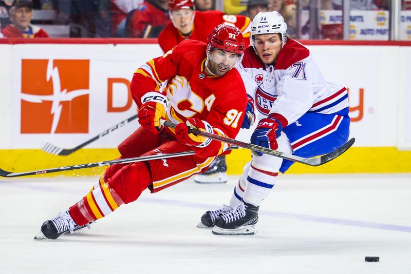 Mar 16, 2024; Calgary, Alberta, CAN; Calgary Flames center Nazem Kadri (91) and Montreal Canadiens center Jake Evans (71) battles for the puck during the second period at Scotiabank Saddledome. Mandatory Credit: Sergei Belski-USA TODAY Sports