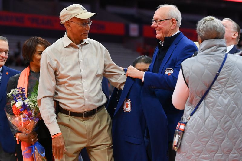 Jan 27, 2024; Syracuse, New York, USA; Former Syracuse Orange head coach Jim Boeheim (right) presents Dave Bing (left) with his Ring of Honor jacket during a ceremony at half time of the game against the North Carolina State Wolfpack at the JMA Wireless Dome. Mandatory Credit: Rich Barnes-USA TODAY Sports