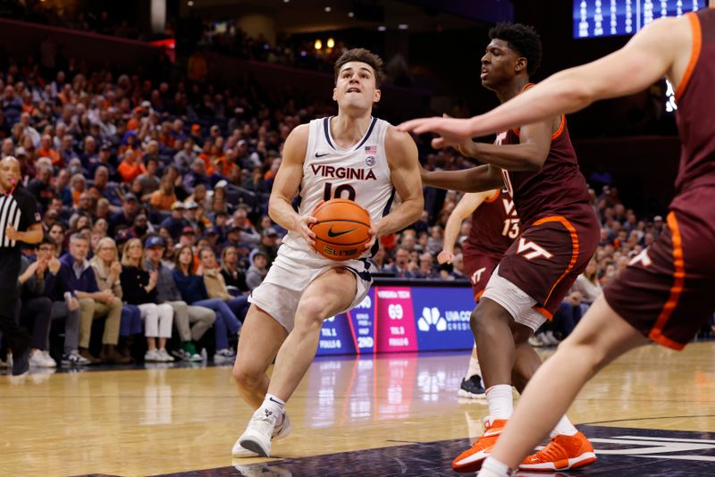 Feb 1, 2025; Charlottesville, Virginia, USA; Virginia Cavaliers guard Taine Murray (10) controls the ball as Virginia Tech Hokies guard Tyler Johnson (10) defends during the second half at John Paul Jones Arena. Mandatory Credit: Amber Searls-Imagn Images