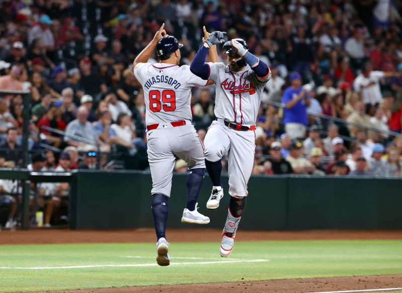 Jul 9, 2024; Phoenix, Arizona, USA; Atlanta Braves outfielder Adam Duvall (right) celebrates with third base coach Matt Tuiasosopo after hitting a three run home run in the sixth inning against the Arizona Diamondbacks at Chase Field. Mandatory Credit: Mark J. Rebilas-USA TODAY Sports