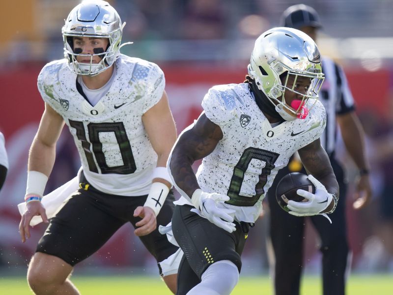 Nov 18, 2023; Tempe, Arizona, USA; Oregon Ducks quarterback Bo Nix (10) hands off the ball to running back Bucky Irving (0) against the Arizona State Sun Devils at Mountain America Stadium. Mandatory Credit: Mark J. Rebilas-USA TODAY Sports