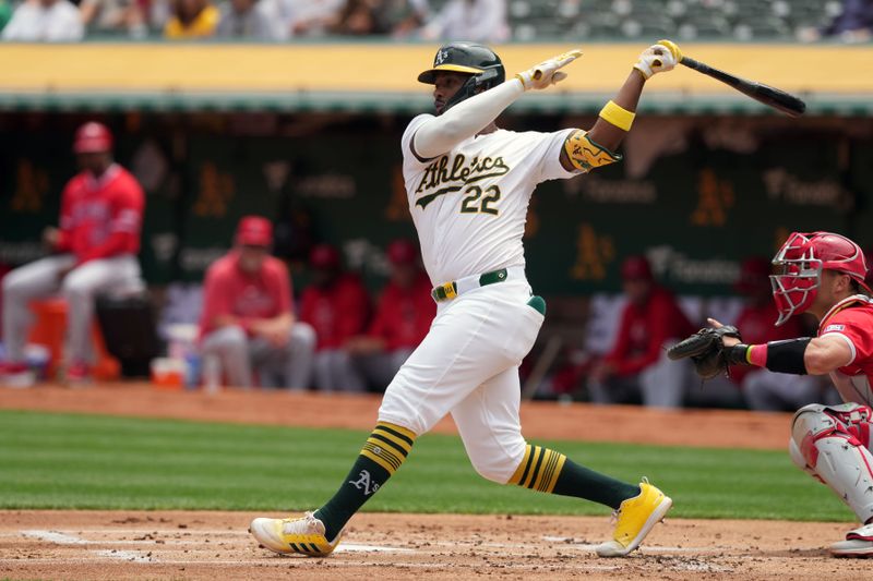 Jul 21, 2024; Oakland, California, USA; Oakland Athletics left fielder Miguel Andujar (22) hits a single against the Los Angeles Angels during the first inning at Oakland-Alameda County Coliseum. Mandatory Credit: Darren Yamashita-USA TODAY Sports