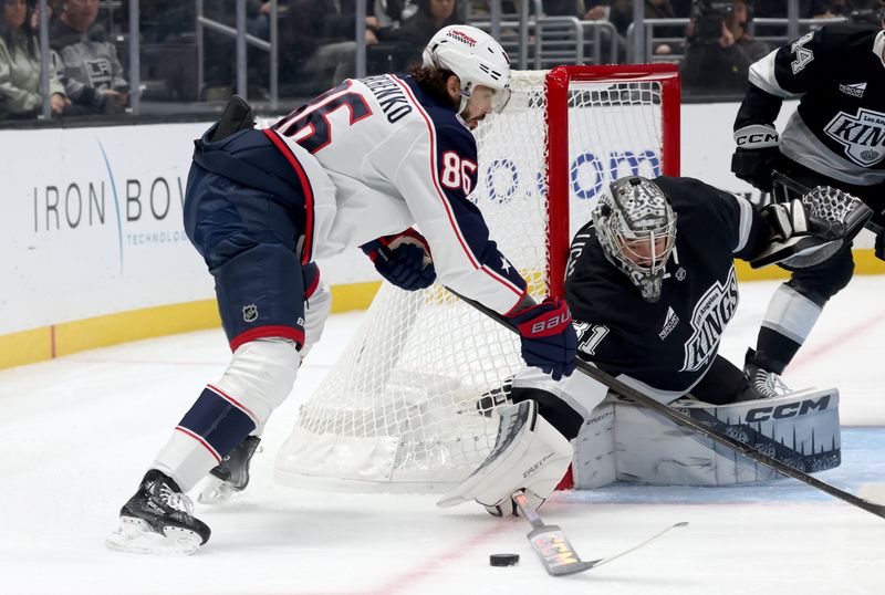 Nov 9, 2024; Los Angeles, California, USA; Los Angeles Kings goaltender David Rittich (31) poke checks the puck from Columbus Blue Jackets right wing Kirill Marchenko (86) during the first period at Crypto.com Arena. Mandatory Credit: Jason Parkhurst-Imagn Images