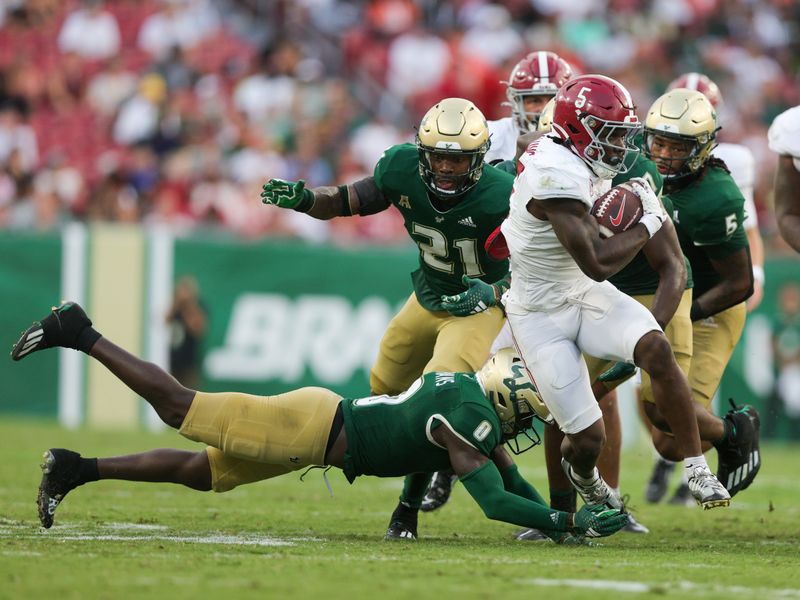 Sep 16, 2023; Tampa, Florida, USA;  Alabama Crimson Tide running back Roydell Williams (5) breaks a tackle from South Florida Bulls defensive back Daquan Evans (0) in the third quarter at Raymond James Stadium. Mandatory Credit: Nathan Ray Seebeck-USA TODAY Sports