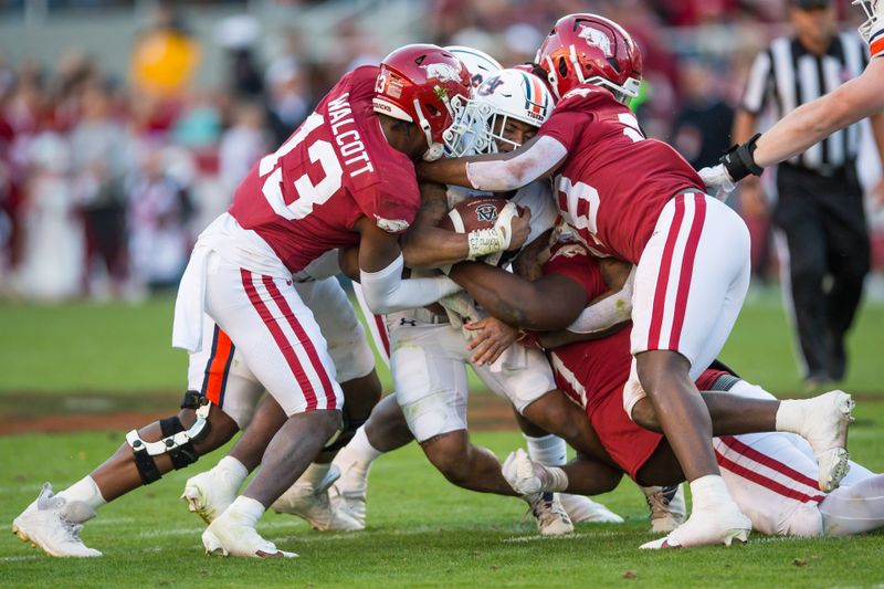 Nov 11, 2023; Fayetteville, Arkansas, USA;  Auburn Tigers running back Jarquez Hunter (27) is tackled by Arkansas Razorbacks defensive back Alfahiym Walcott (13) and linebacker Hayden Brice (28) during the second quarter at Donald W. Reynolds Razorback Stadium. Mandatory Credit: Brett Rojo-USA TODAY Sports