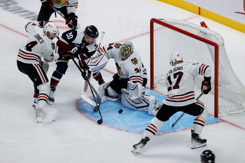 Oct 28, 2024; Denver, Colorado, USA; Colorado Avalanche center Ross Colton (20) battles in front of Chicago Blackhawks goaltender Petr Mrazek (34) against defenseman Seth Jones (4) and left wing Nick Foligno (17) in the second period at Ball Arena. Mandatory Credit: Isaiah J. Downing-Imagn Images