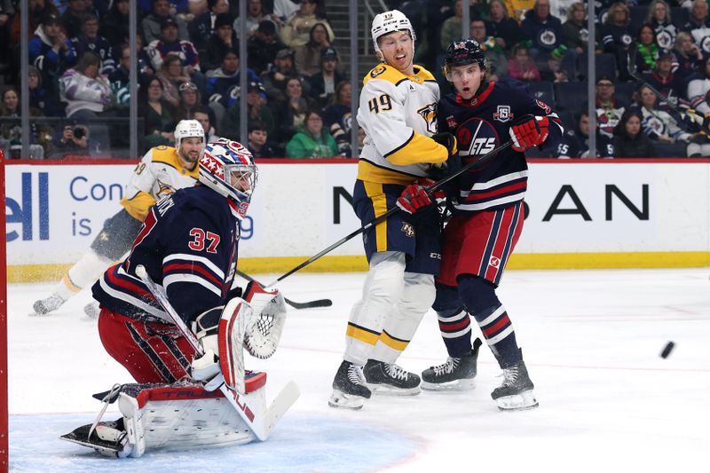 Mar 17, 2026; Winnipeg, Manitoba, CAN; Nashville Predators left wing Reid Schaefer (49) and Winnipeg Jets center Brad Lambert (93) watch an incoming shot on goaltender Connor Hellebuyck (37) in the second period at Canada Life Centre. Mandatory Credit: James Carey Lauder-Imagn Images