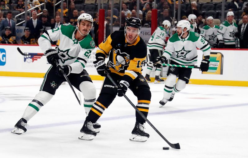 Oct 24, 2023; Pittsburgh, Pennsylvania, USA; Pittsburgh Penguins right wing Reilly Smith (19) carries the puck into the offensive zone ahead of Dallas Stars left wing Mason Marchment (27) during the first period at PPG Paints Arena. Mandatory Credit: Charles LeClaire-USA TODAY Sports