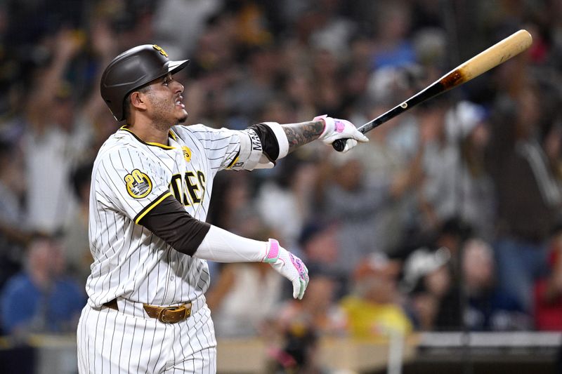 Aug 20, 2024; San Diego, California, USA; San Diego Padres third baseman Manny Machado (13) hits a two-run home run against the Minnesota Twins during the seventh inning at Petco Park. Mandatory Credit: Orlando Ramirez-USA TODAY Sports