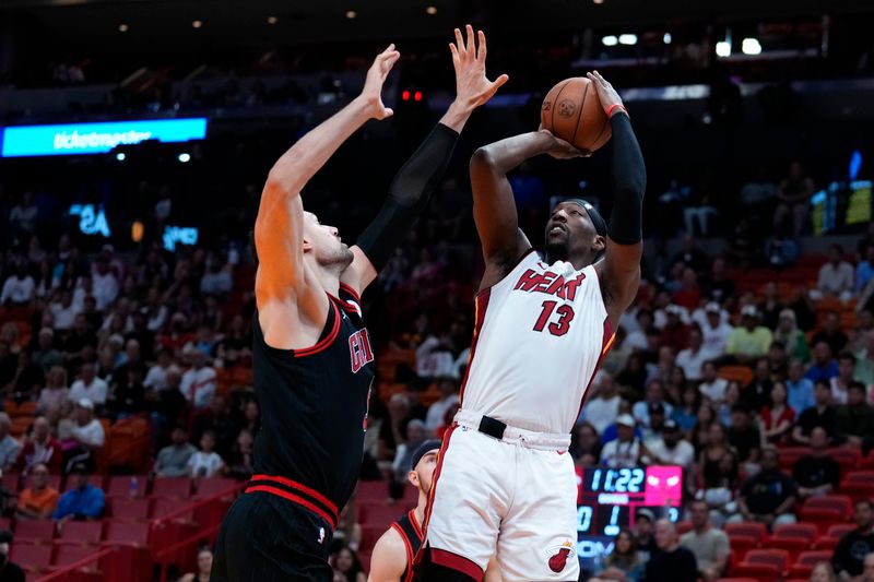 MIAMI, FLORIDA - APRIL 19: Bam Adebayo #13 of the Miami Heat goes up for a shot against Nikola Vucevic #9 of the Chicago Bulls in the first quarter during the Play-In Tournament at Kaseya Center on April 19, 2024 in Miami, Florida. NOTE TO USER: User expressly acknowledges and agrees that, by downloading and or using this photograph, User is consenting to the terms and conditions of the Getty Images License Agreement. (Photo by Rich Storry/Getty Images)