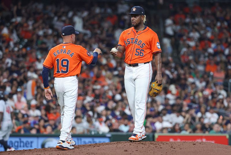 May 31, 2024; Houston, Texas, USA; Houston Astros starting pitcher Ronel Blanco (56) hands the ball to manager Joe Espada (19) during a pitching change in the fifth inning against the Minnesota Twins at Minute Maid Park. Mandatory Credit: Troy Taormina-USA TODAY Sports