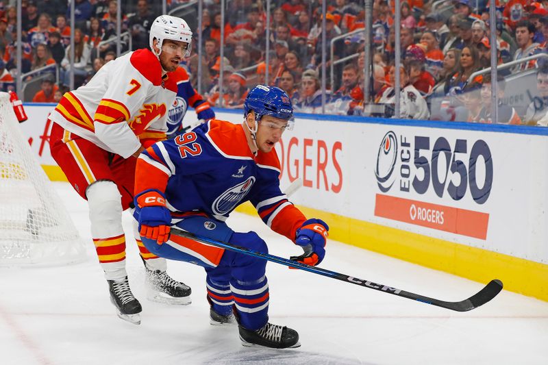 Oct 13, 2024; Edmonton, Alberta, CAN; Edmonton Oilers forward Vasily Podkolzin (92) and Calgary Flames defensemen Kevin Bahl (7) chase a loose puck  during the first period at Rogers Place. Mandatory Credit: Perry Nelson-Imagn Images