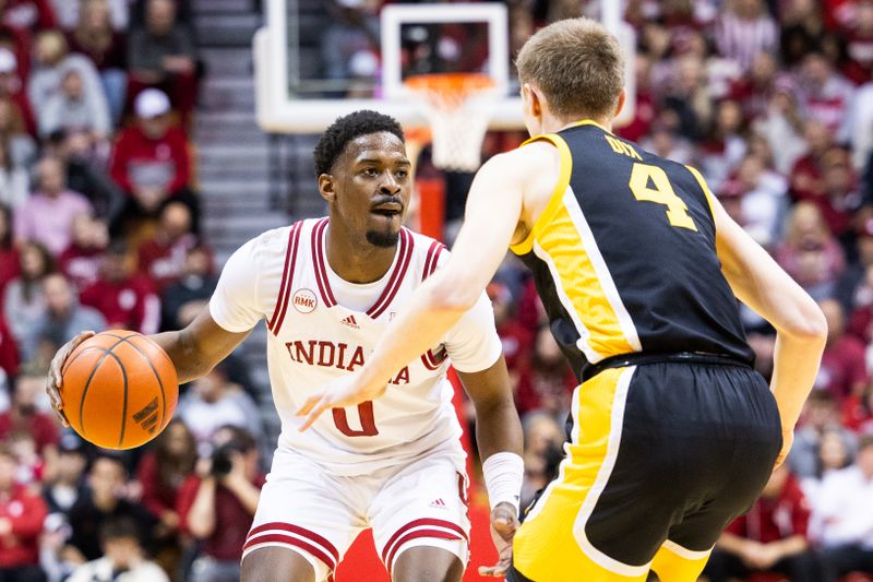 Jan 30, 2024; Bloomington, Indiana, USA; Indiana Hoosiers guard Xavier Johnson (0) dribbles the ball while Iowa Hawkeyes guard Josh Dix (4) defends in the first half at Simon Skjodt Assembly Hall. Mandatory Credit: Trevor Ruszkowski-USA TODAY Sports